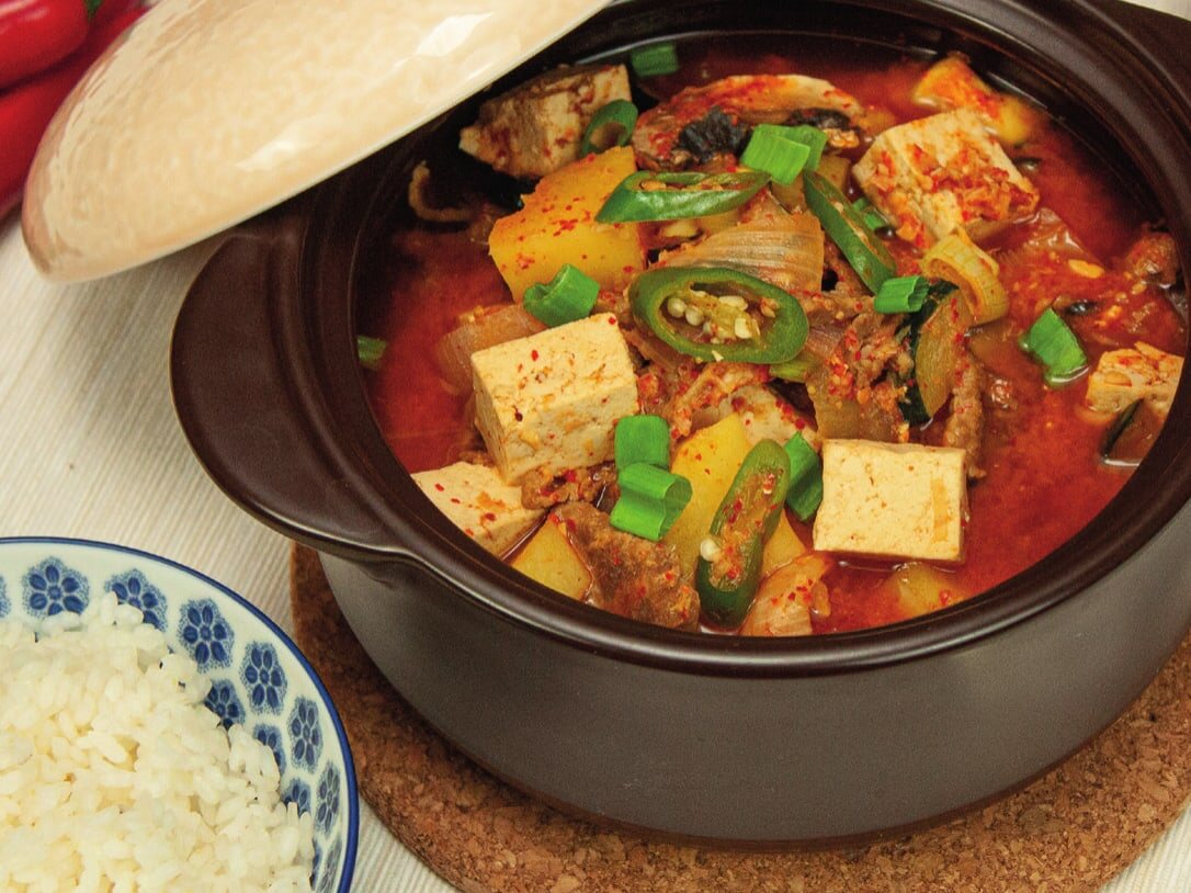 Doenjang-Jjigae im Tontopf mit Tofu, Kartoffel, Chili und Frühlingszwiebeln